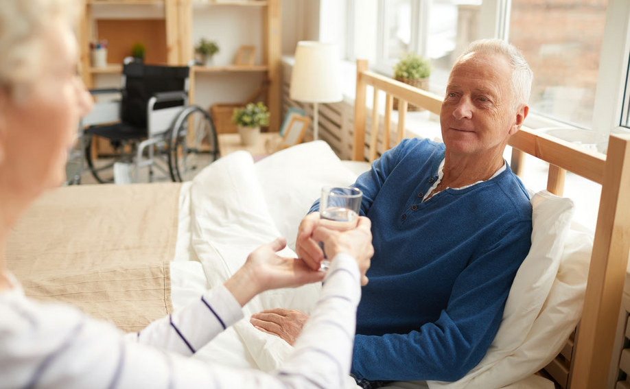 Compassionate caregiver holding the hand of an elderly dementia patient to offer comfort.